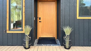 A dark wooden building with a wooden door and two windows. There is a sign above the door that reads "YOSEMITE DREAMIN'".