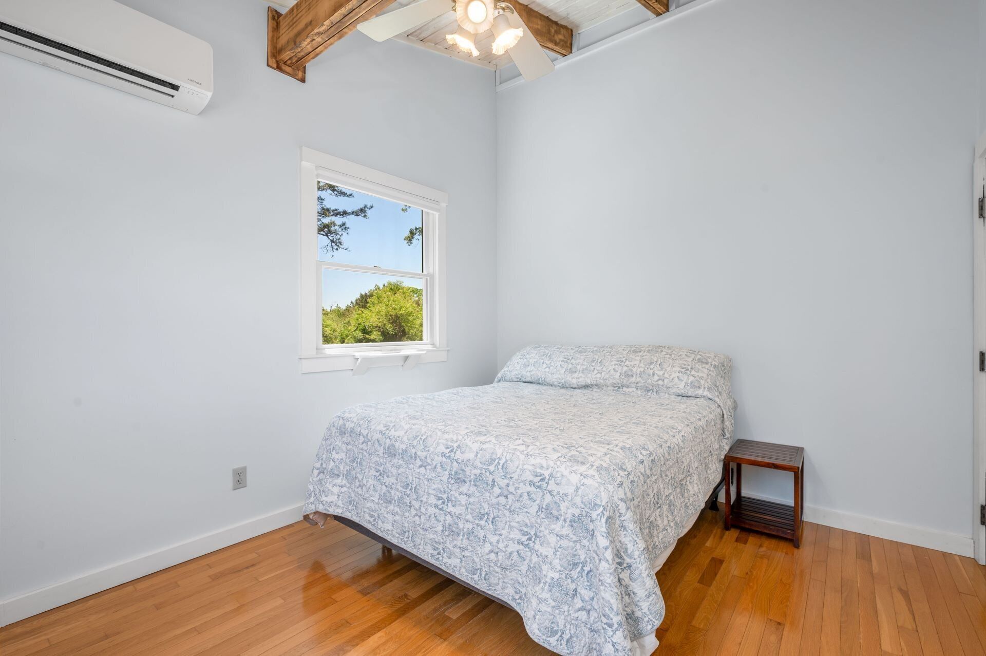 Une chambre à coucher avec un lit, une fenêtre et un appareil de climatisation.