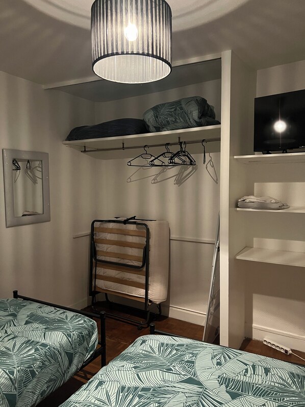 A bedroom with a bunk bed, a chair, a television, and a wardrobe. - Appartement Business Famille 1 (Orléans)