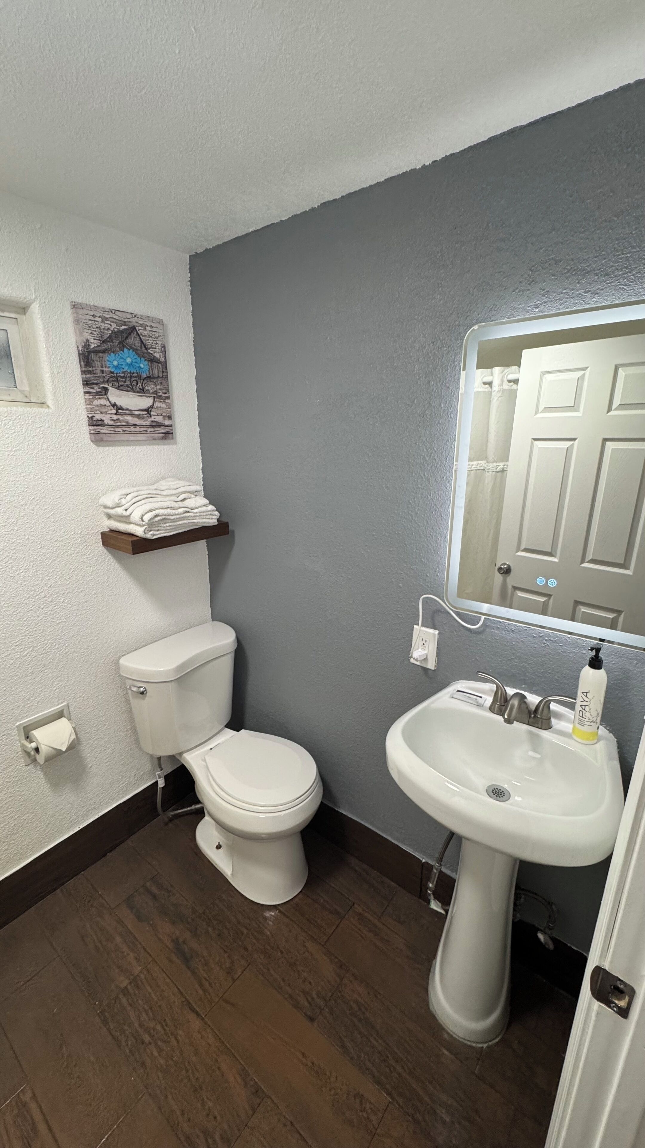 Une salle de bain équipée de toilettes, d’un lavabo et d’un porte-serviettes.