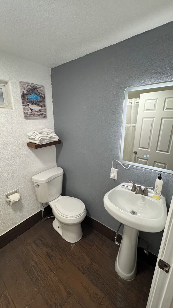 A bathroom with a toilet, sink, and a towel rack.