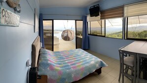A bedroom with a bed, a desk, a chair, a TV, and a view of the landscape. - Cabin2 of Height beautiful Panoramic view and Jacuzzi with hot water on terrace  (Provincia de Alajuela)