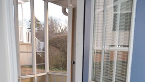 A blue door with a small window, a wooden floor, and a colorful striped mat at the entrance. - Charming 4-bedroom house in welcoming Greenville with WiFi, AC (Greenville)