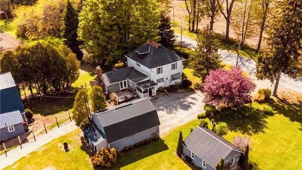 An aerial view of a residential area with multiple houses, a well-maintained lawn, and a variety of trees. - NEWLY UPDATED Quiet Cottage Near Turkey Point and Port Dover (Simcoe)