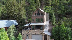 A two-story house with a stone facade, large windows, and a balcony. - Telluride Sunset Ridge Home Spacious and Quiet! View of the Valley Floor and Wildlife (Telluride)