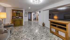 A living room with a marble floor, a television, a sofa, a cabinet, and a lamp. - Comfy Country home. Pet friendly, 5 bedrooms, AC, WIFI, just outside Farmington  (Farmington)