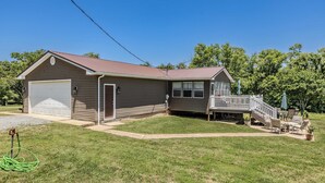 A single-story house with a garage, a covered porch, and a small deck. - Comfy Country home. Pet friendly, 5 bedrooms, AC, WIFI, just outside Farmington  (Farmington)