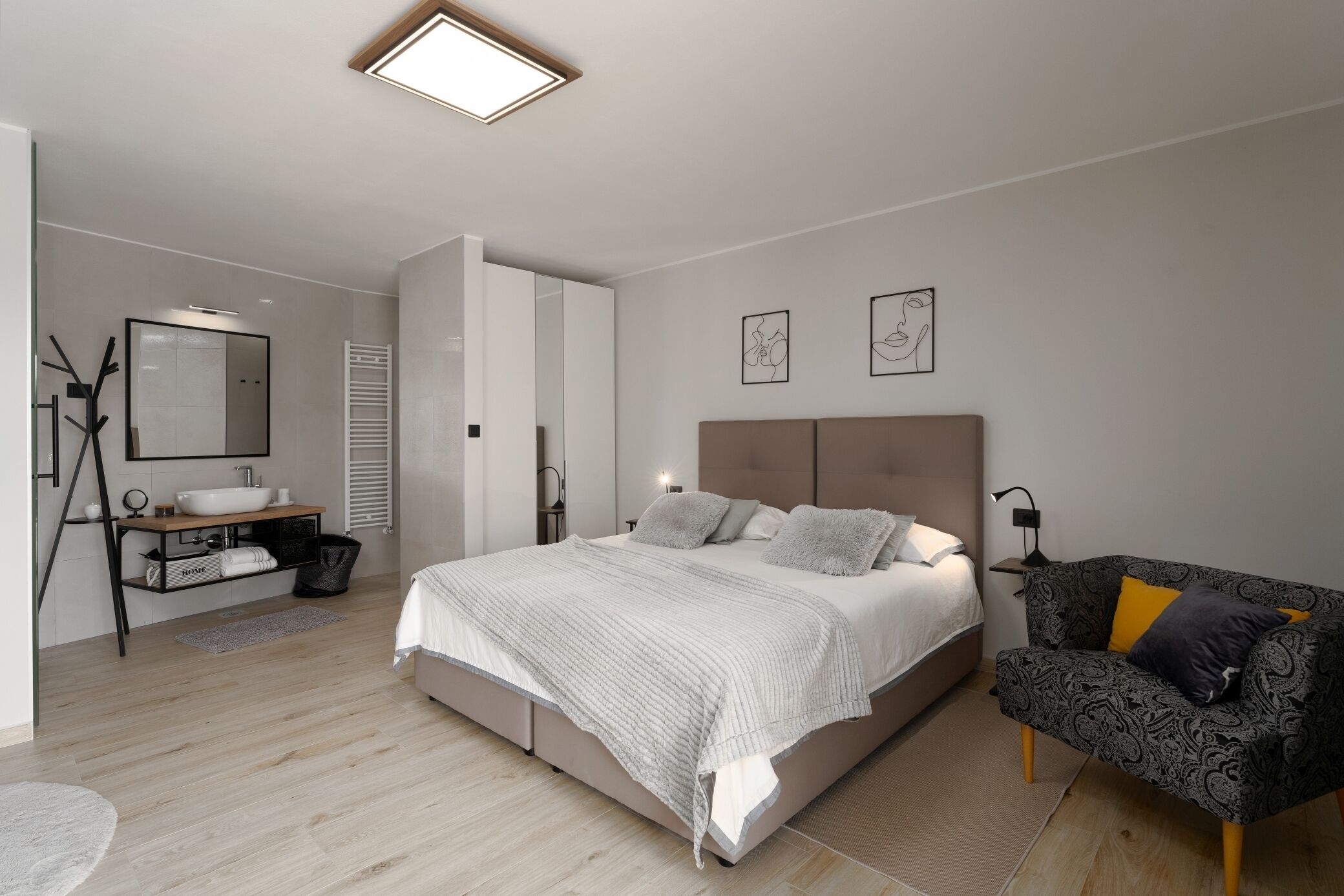 Un dormitorio moderno con cama, mesita de noche y cómoda.