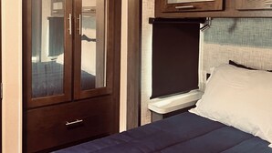 A bedroom with a bed, a wardrobe, and a window. - Grand Lodge Along Best Elk Viewing Road (Benezette)