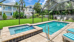 A pool area with a hot tub, lounge chairs, and a view of a residential neighborhood. - Flamingo Beach Hideaway (St. Augustine)