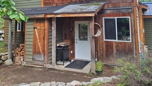 Una casa de madera de dos pisos con un porche delantero, un garaje y un pequeño jardín.