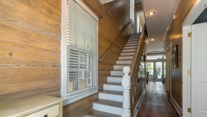 A wooden staircase with white balusters and a white wall on one side. - Boomerang Boathouse (Key West)