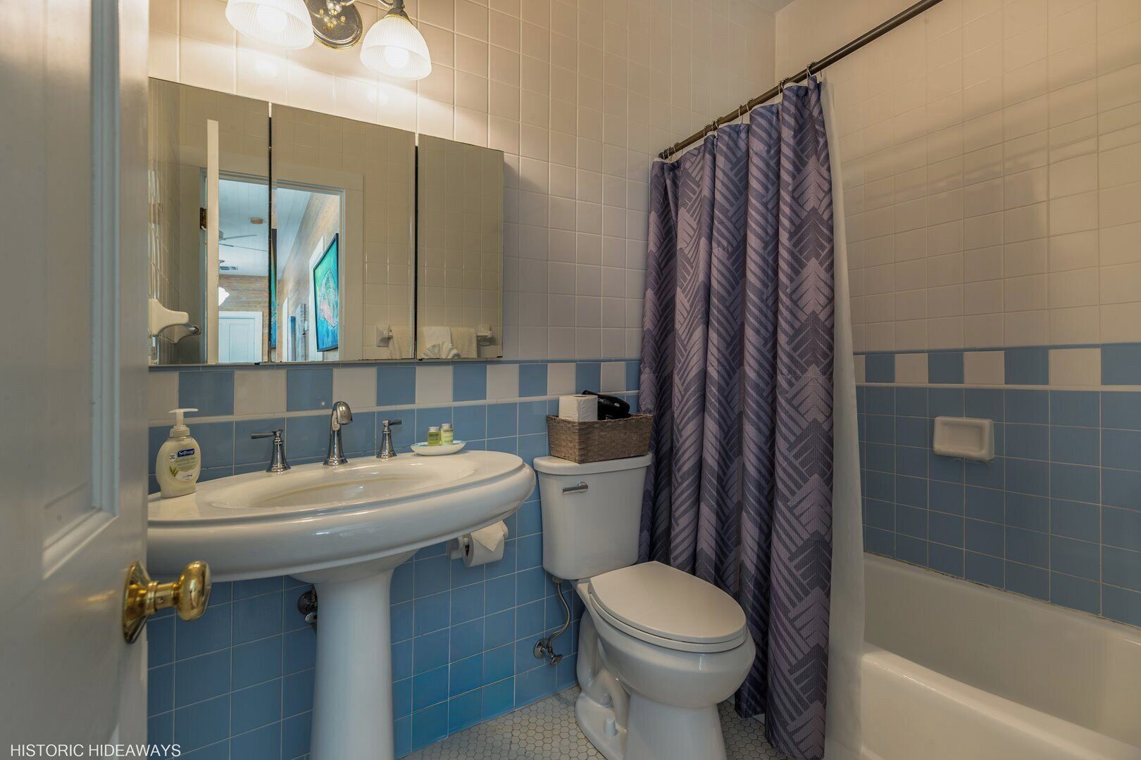 A bathroom with a sink, toilet, and shower curtain.