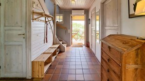 A narrow hallway with wooden benches, a wooden chest of drawers, and a door with a brass handle. - Cozy home in Tjörn with sauna (Tjörn)