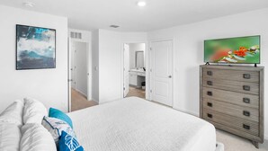 Un dormitorio con cama, cómoda y un cuadro en la pared.