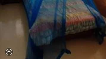 Un dormitorio con una cama cubierta por un dosel azul, dos ventanas y una mesita de noche pequeña.