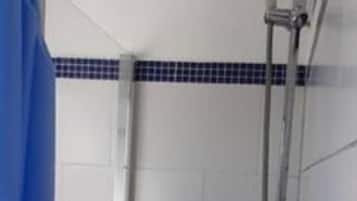 Zona de ducha con cortina azul, cabezal de ducha manual y grifo instalado en la pared.