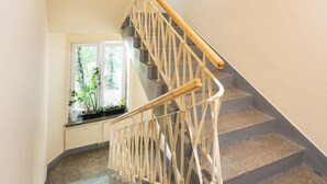 A staircase with a wooden handrail and a geometric railing design. - Plac Politechniki Cosy Studio (Warszawa)