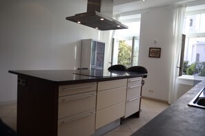 A modern kitchen with a central island, a built-in oven, and a window providing natural light.