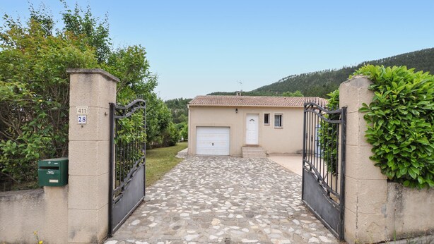 Una casa con entrada de coches pavimentada que conduce a un garaje.