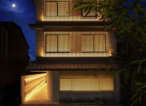 Stylish building with a unique facade, featuring a patterned exterior and a brightly lit entrance.