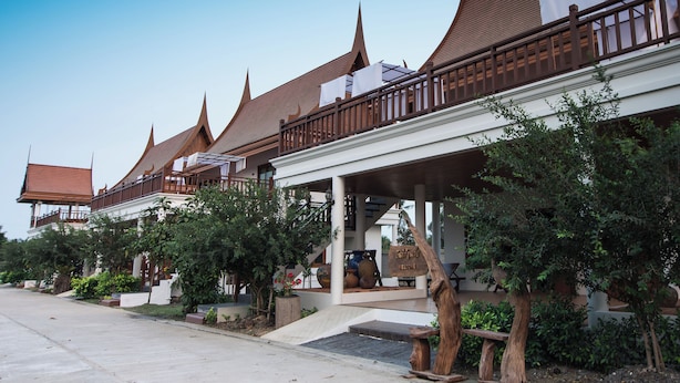 A row of traditional Thai buildings with pointed roofs and wooden balconies. - Thaihome Resort (Bang Kruai)