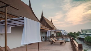 A traditional Thai building with a covered outdoor seating area and a river view. - Thaihome Resort (Bang Kruai)