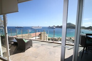 Enjoy the ocean view from this balcony with a clear view of cruise ships, beach, and mountains.