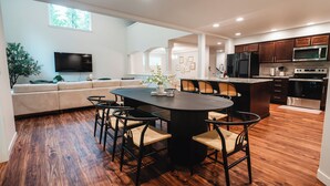 Une cuisine moderne dotée d’un îlot central, de planchers en bois et d’appareils électroménagers intégrés.
