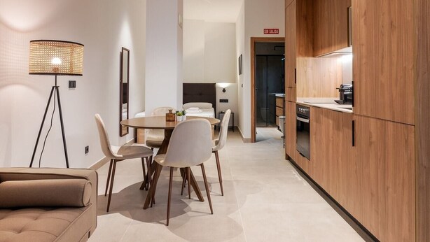 A modern interior with a dining area, a sofa, a lamp, and wooden cabinetry. - VLC HOST - Zapadores B (València)