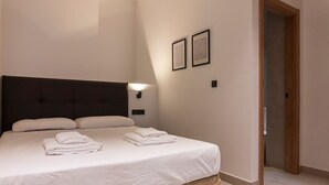 A neatly made bed with white linens and pillows, a dark headboard, and two framed artworks on the wall. - VLC HOST - Zapadores B (València)
