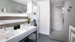 A modern bathroom with a large mirror, two sinks, a shower, and a potted orchid. - Design flat - Pesce (Piano di Sorrento)