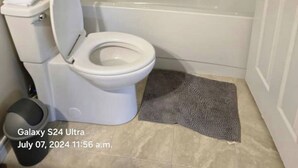 A bathroom with a toilet, a bathtub, and a shower. - This is a family-friendly place. (Dartmouth)