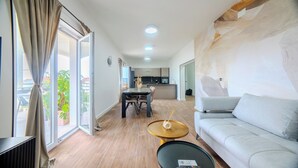Un salon moderne comprenant un canapé, une table basse et un coin repas avec une table et des chaises.