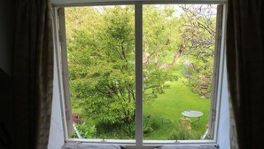 Una habitación con un gran ventanal con vistas a un jardín.