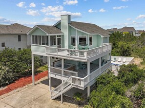 A two-story house with a balcony, a hot tub, and a pool. - Searenity | 810 ft to the beach | Private Pool, Hot Tub, and Dog Friendly (Corolla)