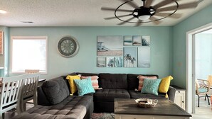 A living room with a sectional sofa, a coffee table, and a ceiling fan. - Waterway Haven (North Myrtle Beach)