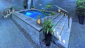 A modern indoor pool with a stone border, surrounded by potted plants and candles. - SKI IN/OUT RESORT AT BRECKENRIDGE - GRAND COLORADO ON PEAK EIGHT 
CHRISTMAS TIME (Breckenridge)