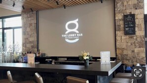 A bar area with a logo, a menu board, and a stone wall. - SKI IN/OUT RESORT AT BRECKENRIDGE - GRAND COLORADO ON PEAK EIGHT 
CHRISTMAS TIME (Breckenridge)