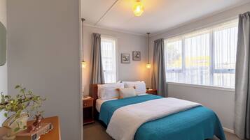 2 habitaciones, escritorio y tabla de planchar con plancha