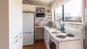 A compact kitchen with white appliances, a microwave, a toaster, and a stove. - ◇◇NO CLEANING FEE◇◇
Cottage135 Rotorua - Family-friendly holiday home (Rotorua)
