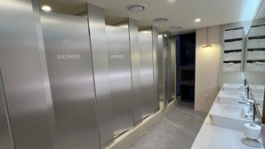 Une salle de bain moderne dotée de plusieurs douches, d’un meuble-lavabo et d’un miroir.