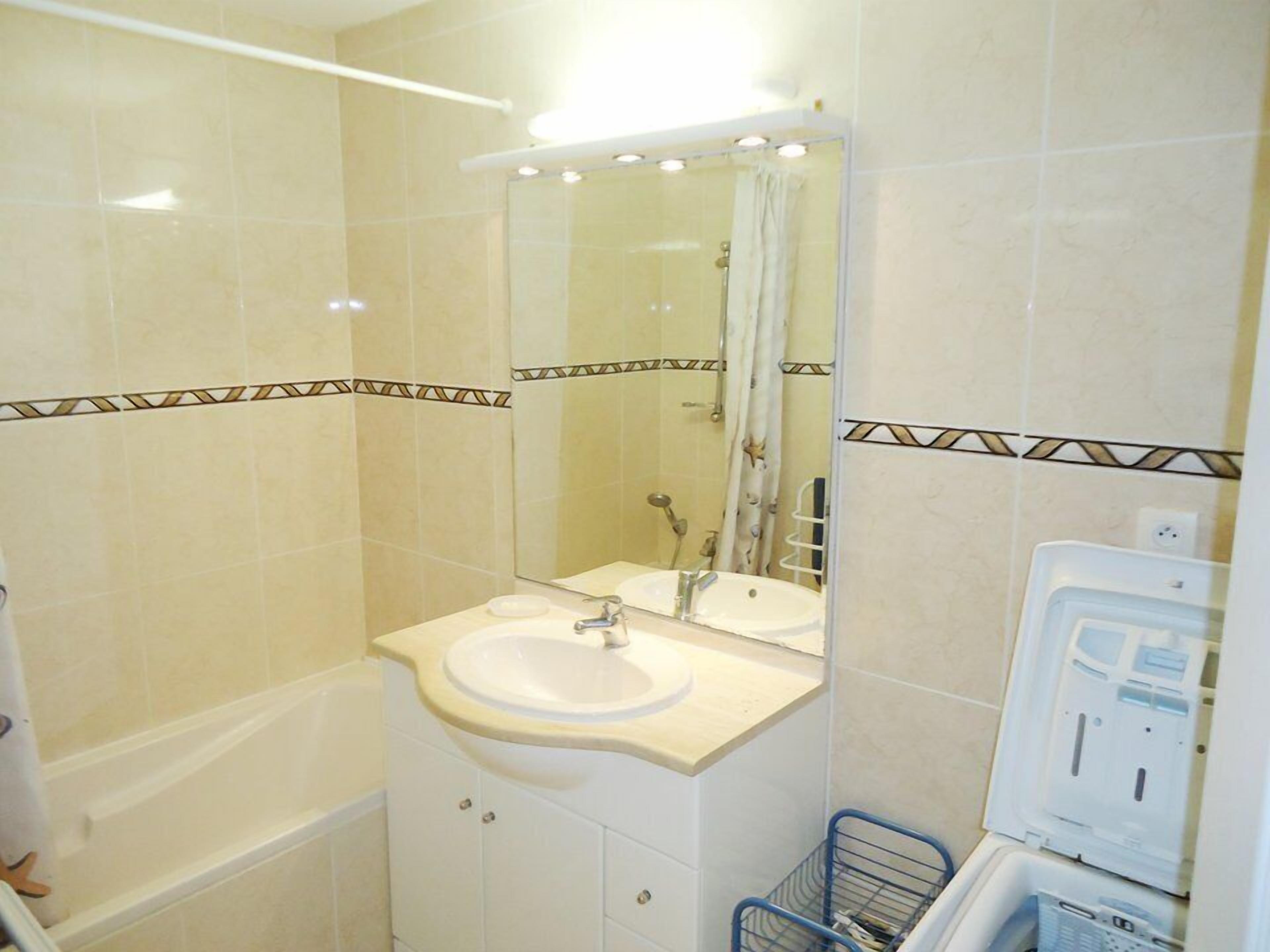 Een badkamer met een bad, een wastafel, een spiegel en een douche.