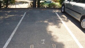 Un espace de stationnement avec des places délimitées et un îlot central.