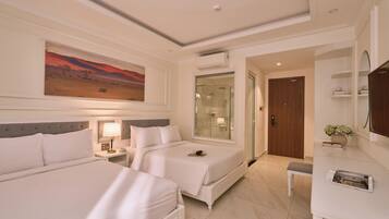A hotel room with two beds, a large painting, a glass shower enclosure, a wooden door, and a small bench.