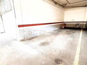 A parking garage with concrete floors and a red stripe marking the edge. - Apartment with large terrace in Costa Adeje. (Costa Adeje)
