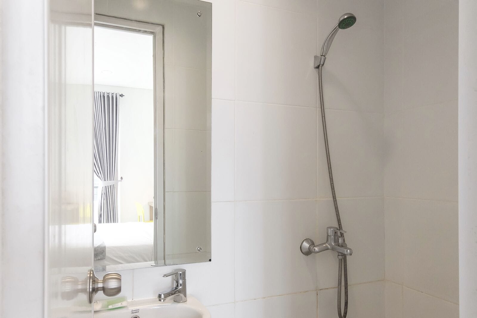 A bathroom with a shower, a sink, and a mirror.