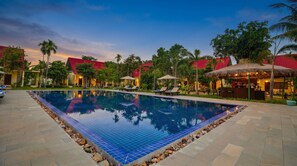 A pool with tiled edges, lounge chairs, and a bar area with umbrellas. - Habana Angkor Resort (Siem Reap)