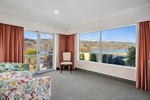 A room with a large window, a chair, and a floral sofa. - Mount Pisa Lake View (Mount Pisa)