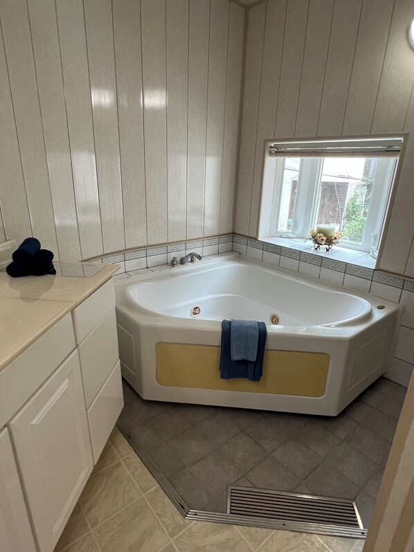 A bathroom with a freestanding bathtub, a window with a view, and a towel rack. - A spacious and beautiful Western-style home. Enjoy sightseeing in Kamakura with a stylish stay! (Kamakura)